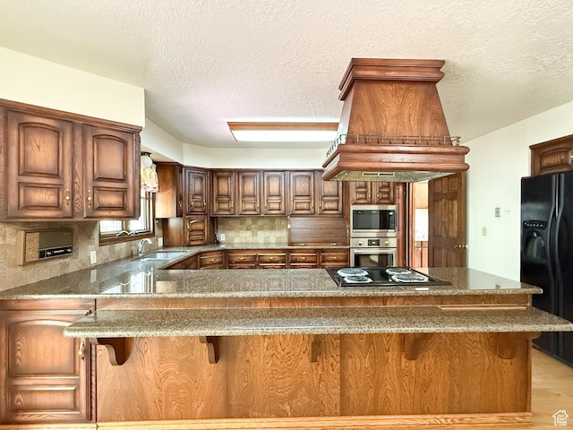 1145 E 1675 N, North Ogden, UT 84404 - kitchen with black appliances, stone counters, a sink, backsplash, and a peninsula
