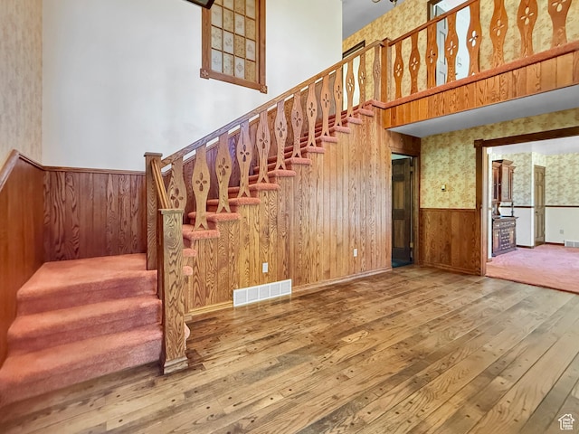 1145 E 1675 N, North Ogden, UT 84404 - stairway featuring hardwood / wood-style flooring, a wainscoted wall, wooden walls, wallpapered walls, and a towering ceiling