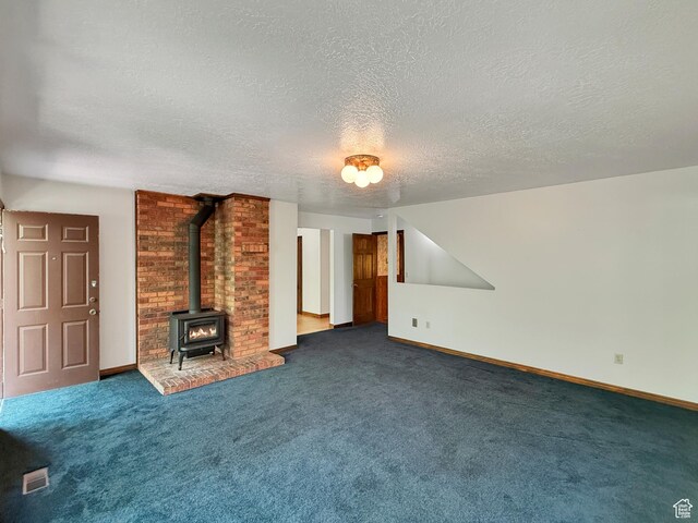 1145 E 1675 N, North Ogden, UT 84404 - unfurnished living room with a wood stove, a textured ceiling, dark carpet, and baseboards