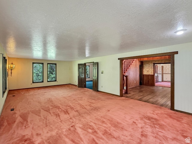 1145 E 1675 N, North Ogden, UT 84404 - unfurnished living room featuring a textured ceiling, carpet, baseboards, and wooden walls