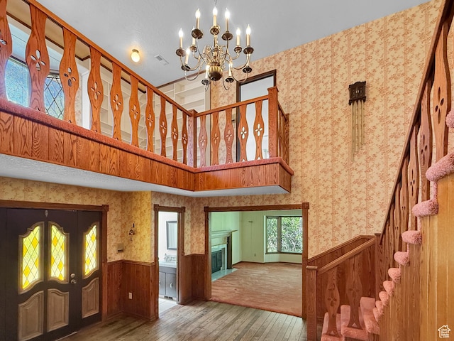1145 E 1675 N, North Ogden, UT 84404 - stairs featuring wood-type flooring, a wainscoted wall, a chandelier, french doors, and a high ceiling