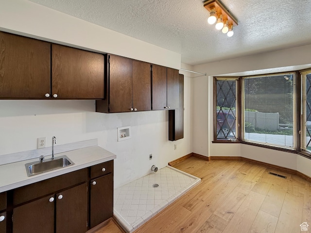 1145 E 1675 N, North Ogden, UT 84404 - washroom featuring cabinet space, washer hookup, light wood finished floors, baseboards, and a textured ceiling