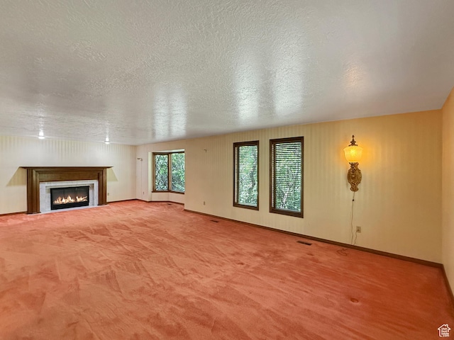 1145 E 1675 N, North Ogden, UT 84404 - unfurnished living room with a textured ceiling, carpet flooring, a fireplace with flush hearth, and baseboards