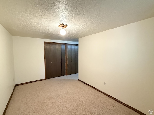 1145 E 1675 N, North Ogden, UT 84404 - unfurnished bedroom featuring a closet, baseboards, a textured ceiling, and light colored carpet