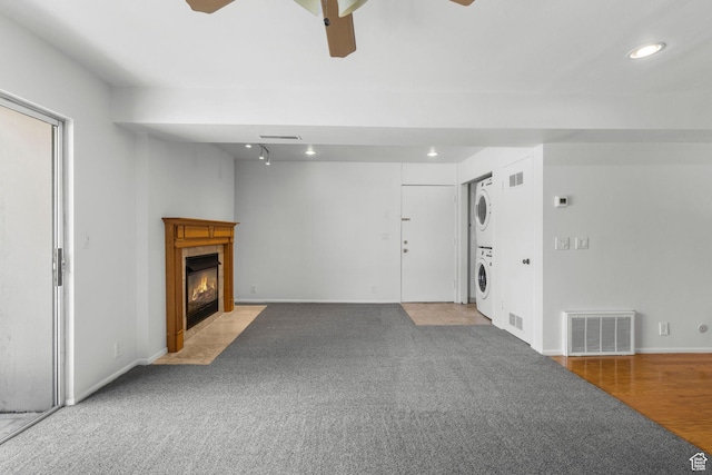 4878 S Highland Cir Unit 6, Salt Lake City, UT 84117 - unfurnished living room with stacked washer / drying machine, a ceiling fan, recessed lighting, a tile fireplace, and light colored carpet