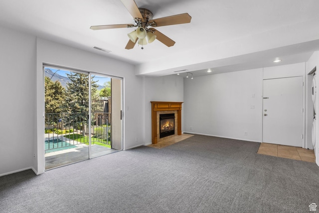 4878 S Highland Cir Unit 6, Salt Lake City, UT 84117 - unfurnished living room with carpet flooring, a ceiling fan, a fireplace, and baseboards