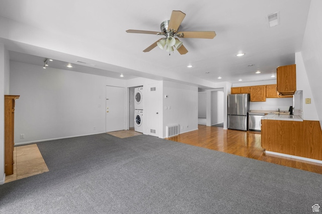 4878 S Highland Cir Unit 6, Salt Lake City, UT 84117 - unfurnished living room featuring stacked washer / drying machine, recessed lighting, a ceiling fan, carpet, and baseboards