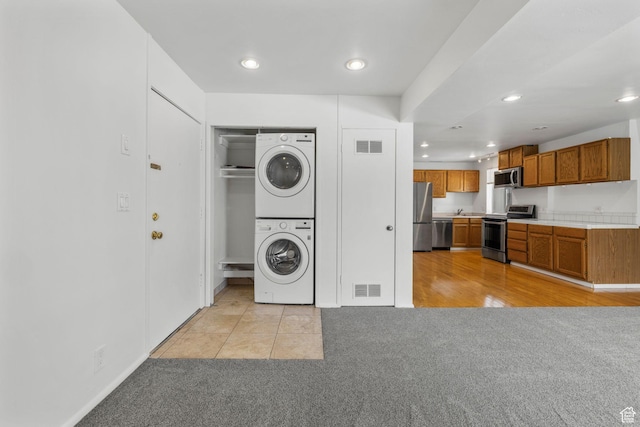 4878 S Highland Cir Unit 6, Salt Lake City, UT 84117 - washroom with stacked washer / dryer, light colored carpet, and recessed lighting