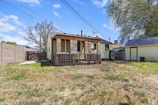 rear view of property featuring a gate and a fenced backyard