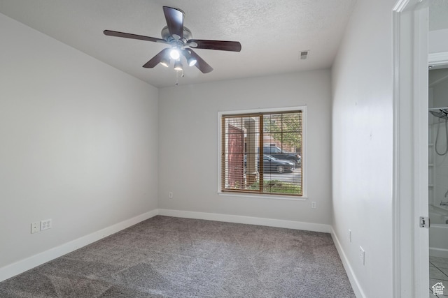 carpeted spare room featuring ceiling fan, baseboards, and a textured ceiling