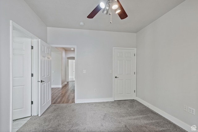 unfurnished bedroom featuring carpet floors, baseboards, and ceiling fan