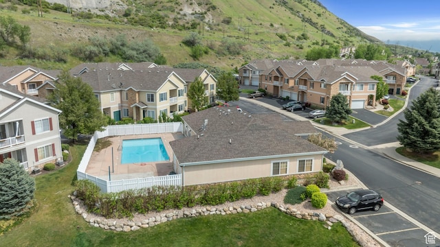 aerial view of residential area featuring a pool and a mountain backdrop