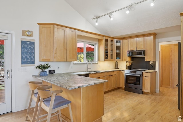 kitchen with stainless steel electric range, a sink, vaulted ceiling, a peninsula, and rail lighting