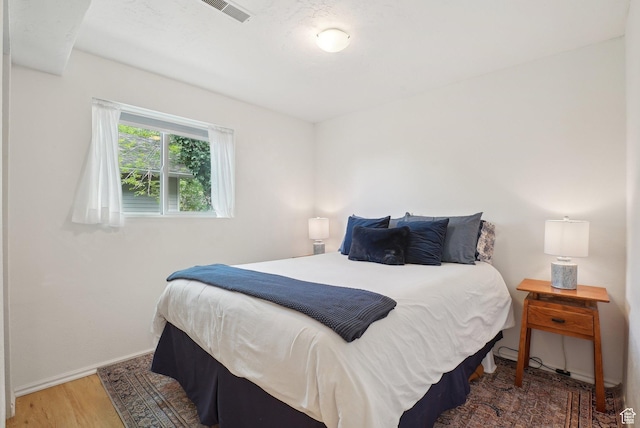 bedroom with wood finished floors and baseboards