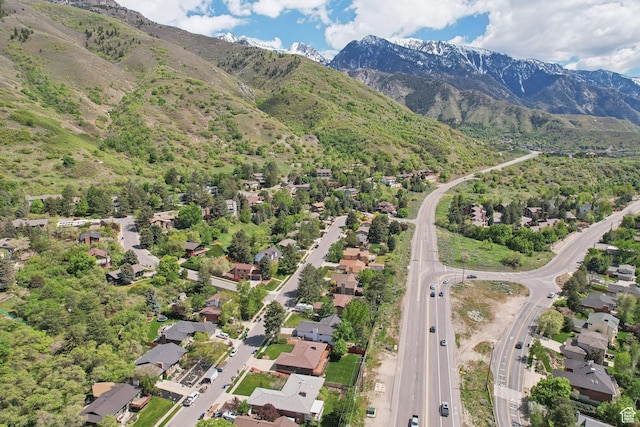aerial view of property and surrounding area featuring mountains and nearby suburban area