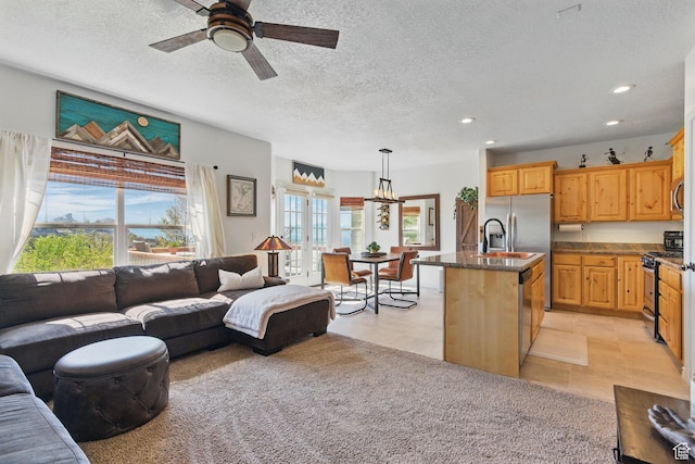 living room featuring plenty of natural light, recessed lighting, a ceiling fan, a textured ceiling, and a chandelier