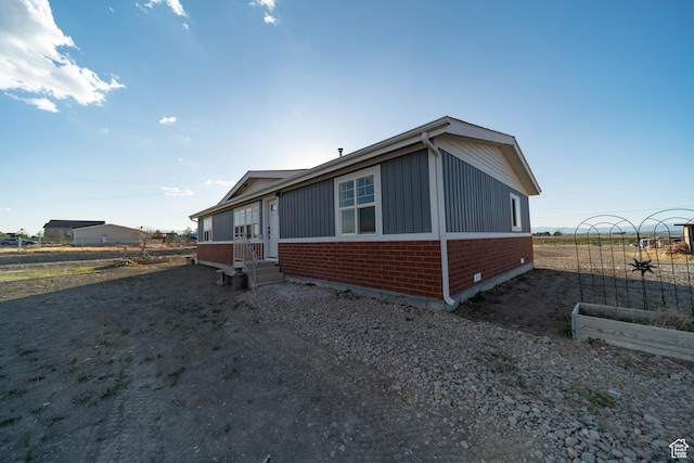 1691 E 8900 S, Price, UT 84501 - view of side of property with brick siding, entry steps, board and batten siding, and a vegetable garden