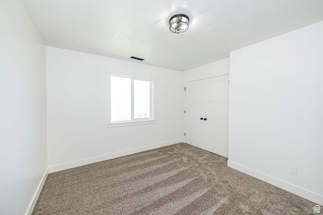 carpeted spare room featuring baseboards