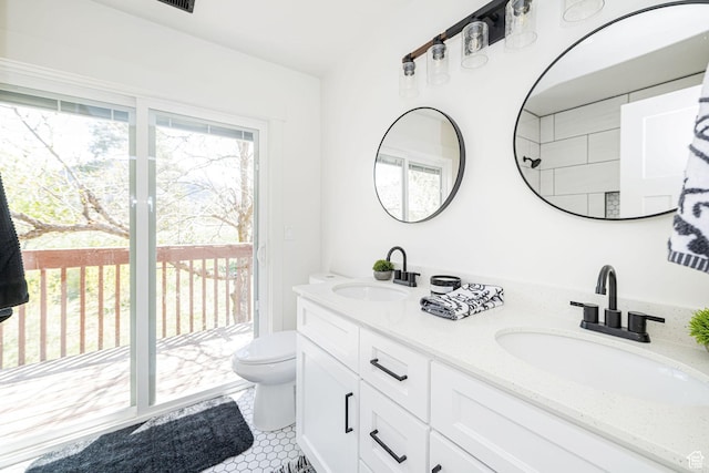 bathroom featuring toilet, double vanity, and tile patterned flooring