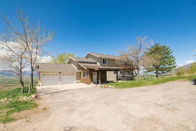 view of front of home with a garage, dirt driveway, and covered porch