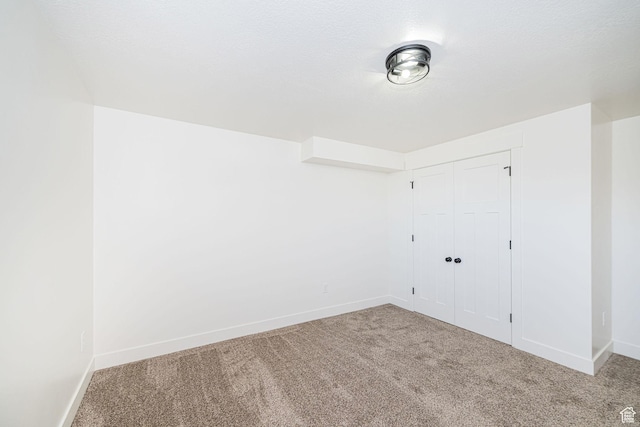 unfurnished bedroom with carpet, baseboards, and a closet