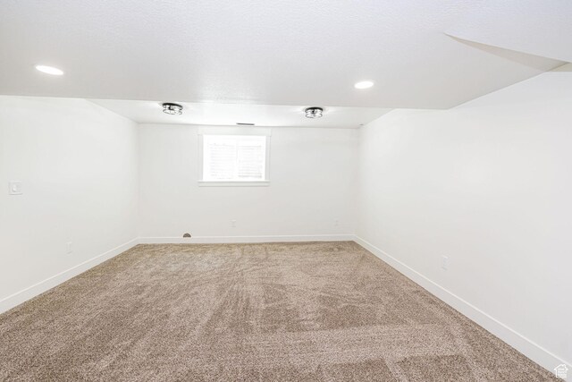 empty room with light carpet, baseboards, and recessed lighting