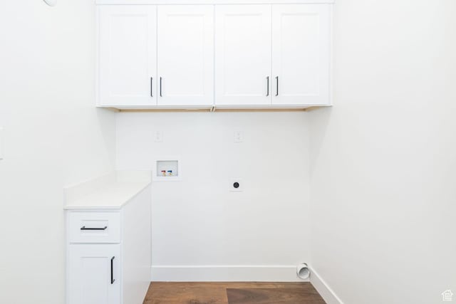 washroom with hookup for an electric dryer, hookup for a washing machine, cabinet space, baseboards, and dark wood finished floors