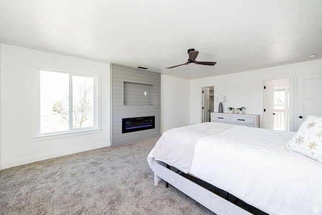 bedroom with carpet, baseboards, a fireplace, and ceiling fan