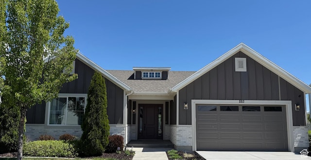 view of front of home with board and batten siding, a garage, a shingled roof, and driveway