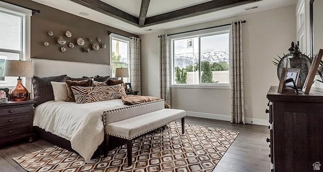 bedroom featuring wood finished floors, baseboards, and beam ceiling