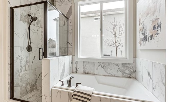 full bathroom featuring a stall shower and a bath