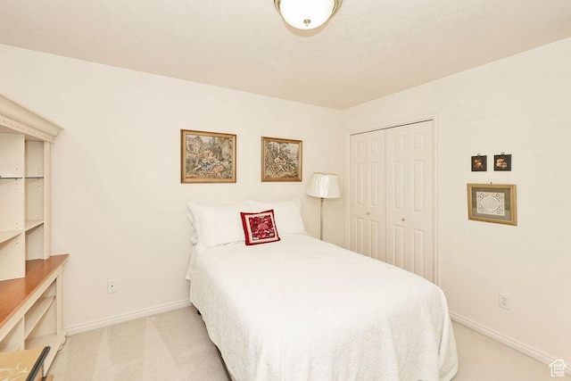 bedroom with light colored carpet, baseboards, and a closet