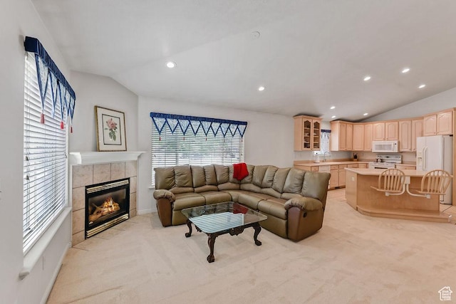 living room featuring lofted ceiling, light colored carpet, a tiled fireplace, and recessed lighting