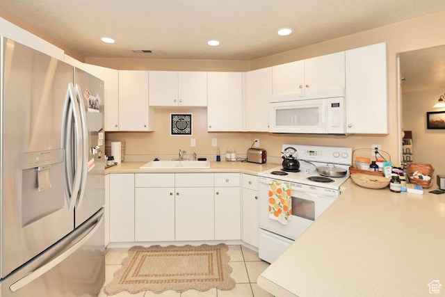 kitchen featuring white appliances, a sink, light countertops, white cabinets, and recessed lighting