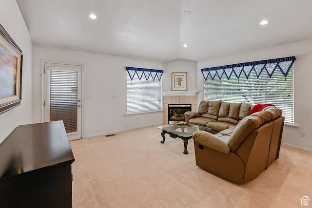 living area with baseboards, a tiled fireplace, healthy amount of natural light, and recessed lighting