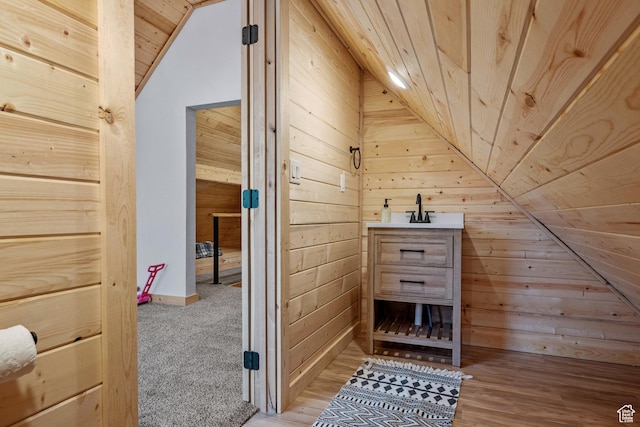 bathroom featuring vaulted ceiling, wood walls, and wood ceiling