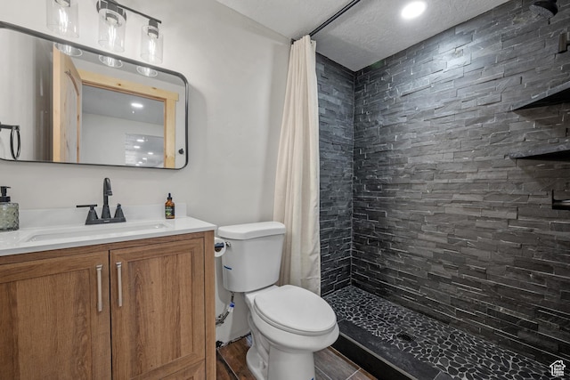full bathroom featuring toilet, tiled shower, vanity, and recessed lighting
