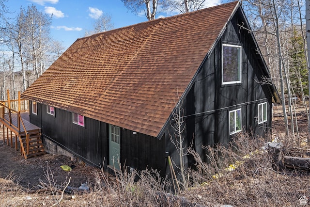 view of property exterior with a shingled roof