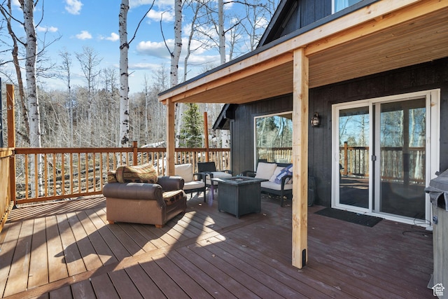 wooden terrace featuring an outdoor living space with a fire pit