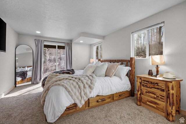 bedroom with light colored carpet, multiple windows, recessed lighting, and a textured ceiling