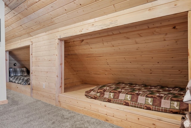 unfurnished bedroom featuring wooden walls and carpet floors