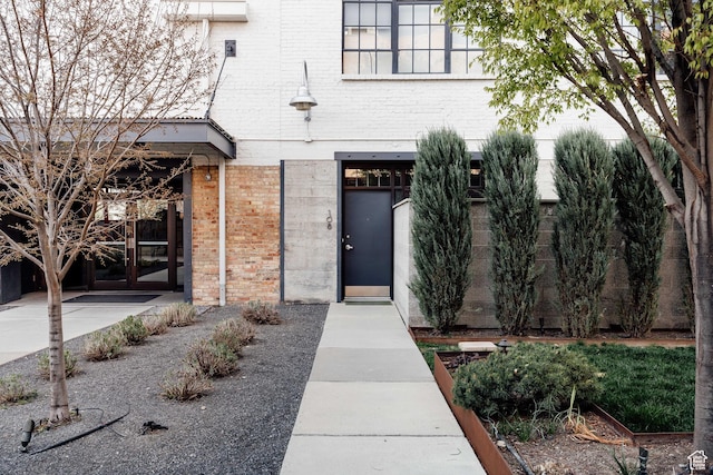 view of exterior entry featuring brick siding and french doors