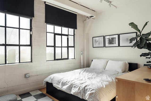 bedroom with track lighting and tile patterned floors