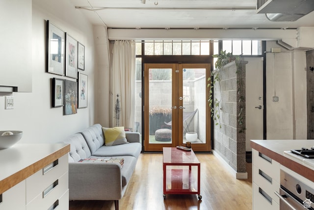 living area with light wood-style flooring and french doors