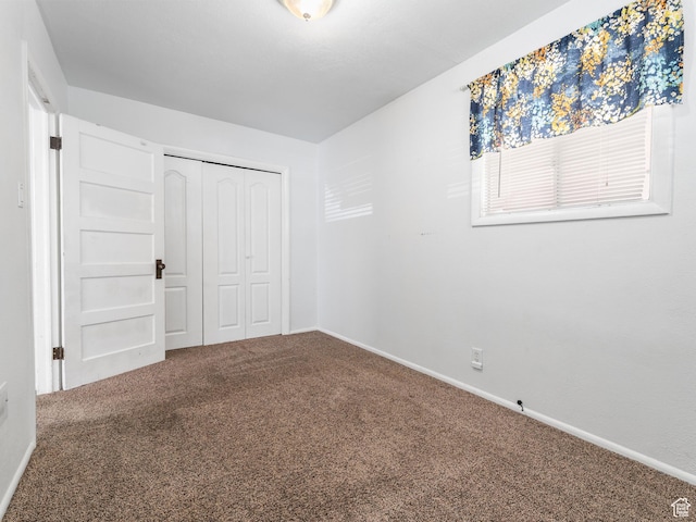 unfurnished bedroom featuring carpet floors, a closet, and baseboards