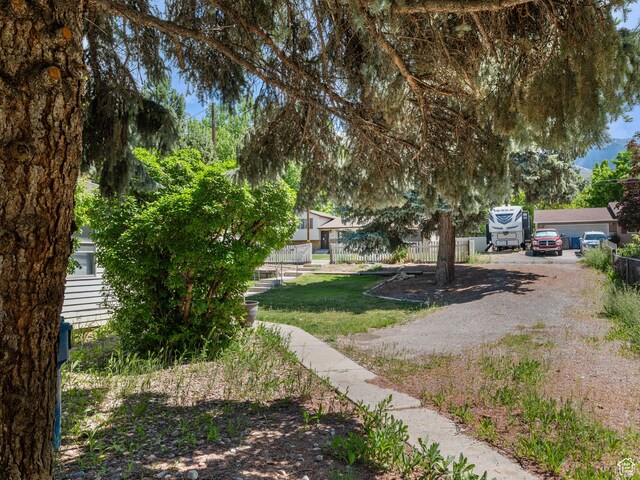 view of yard featuring fence and driveway