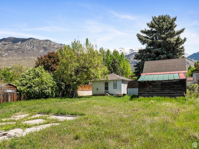 view of yard with a storage unit, a mountain view, and an outbuilding