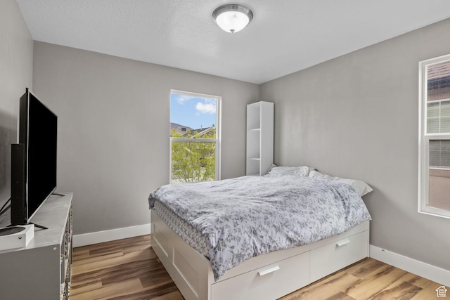 bedroom with baseboards and light wood-style floors