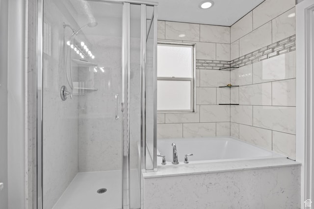 bathroom with a shower stall and a bath
