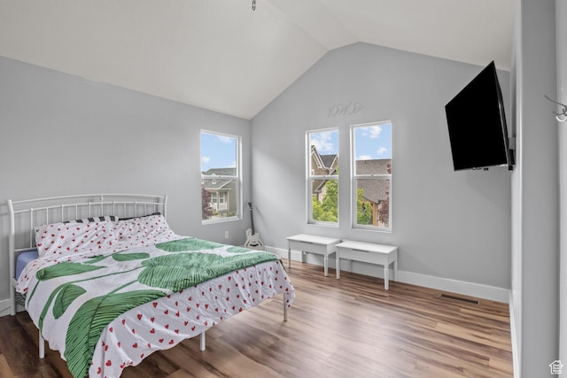 bedroom featuring vaulted ceiling, wood finished floors, and baseboards